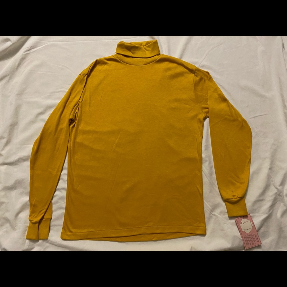 This is a gold bobbie brooks long sleeve turtleneck in a size medium.